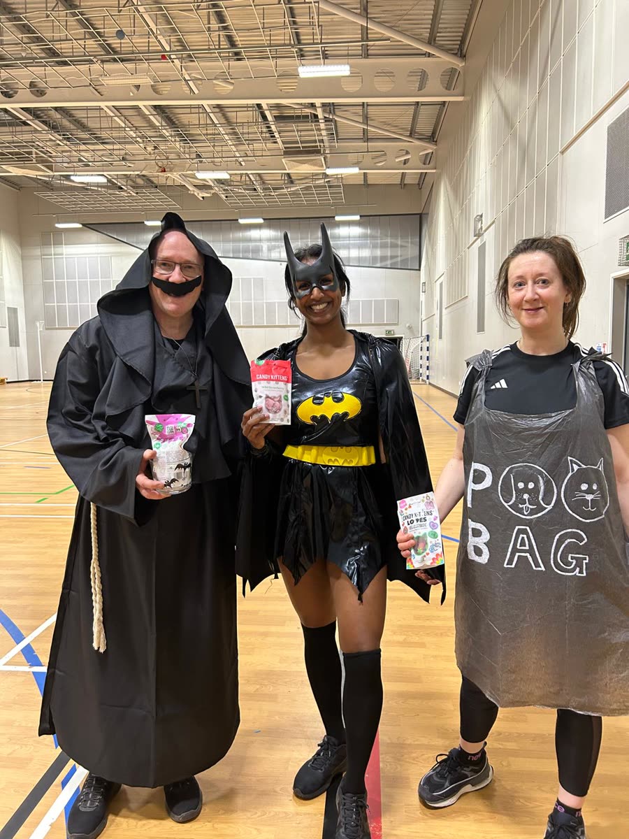Three players in fancy dress holding their prizes