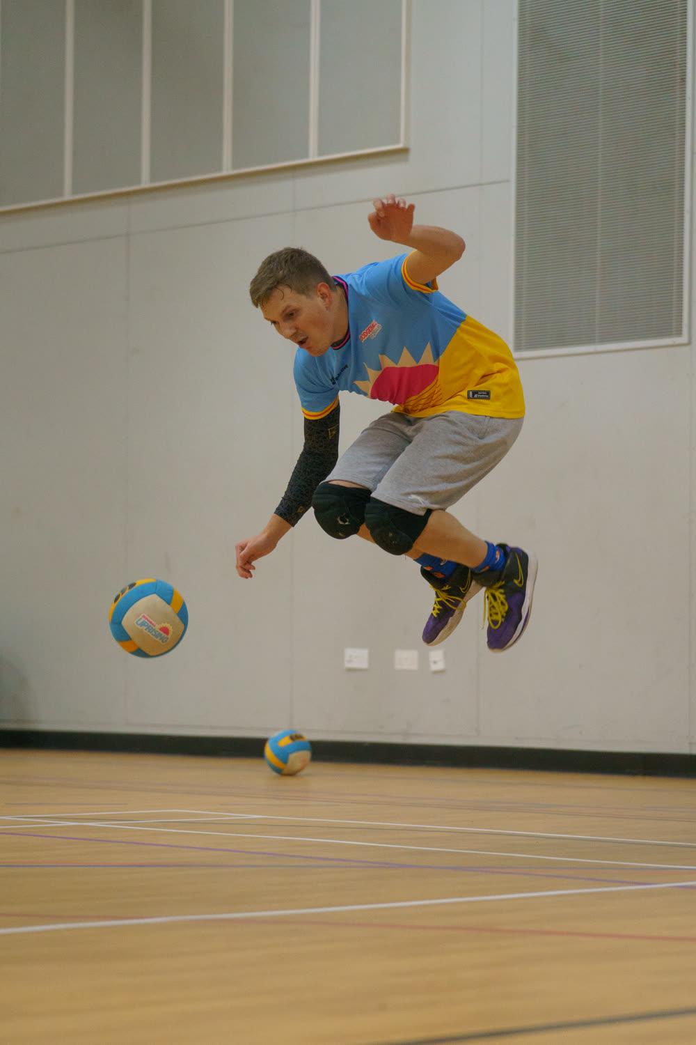 A player leaping clear of two dodgeballs